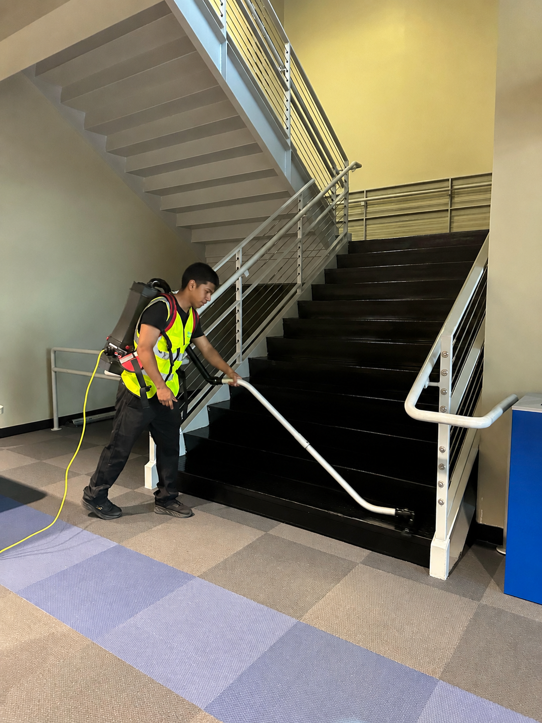 Caring Commercial Cleaning Inc. crew member cleaning a government facility stairwell in Houston, TX