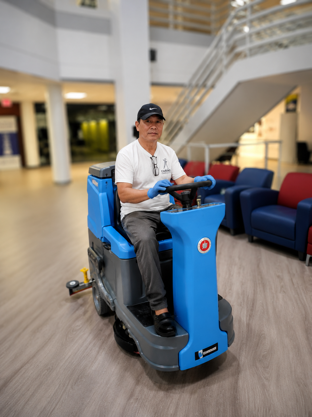 Caring Commercial Cleaning crew member operating floor scrubber in government facility