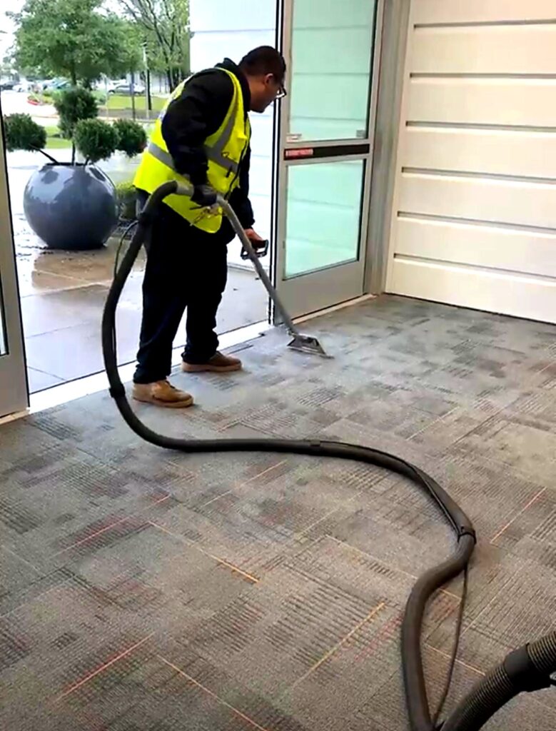 Professional carpet cleaning service in progress at building entrance.