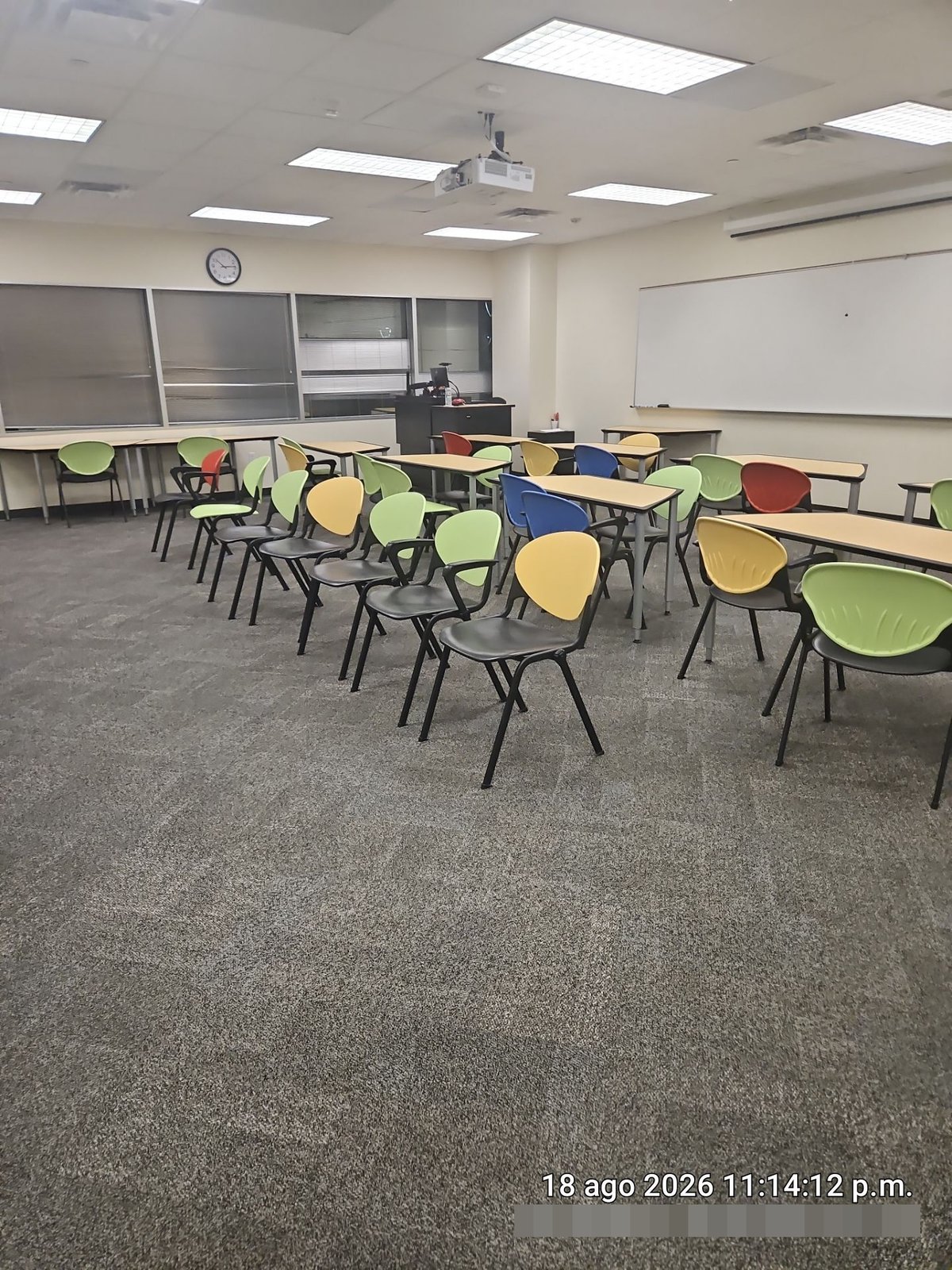 Clean carpeted classroom with chairs and desks in order