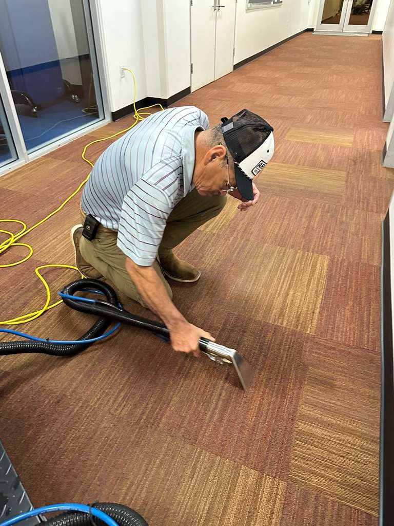 Caring Commercial Cleaning technician performing hot water extraction carpet cleaning in a Houston office building