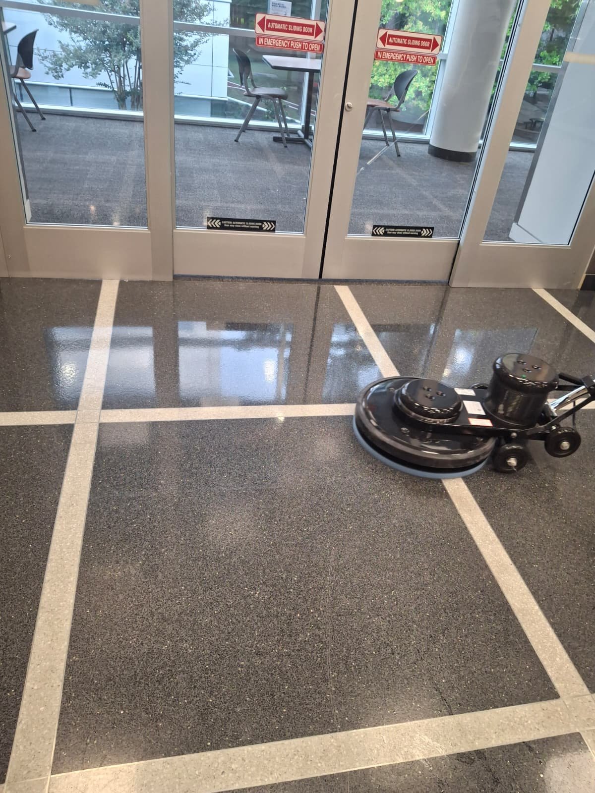 Floor buffing machine polishing terrazzo at a facility entrance