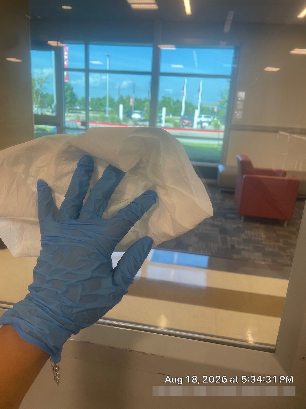 Technician cleaning interior glass partition to a streak-free finish