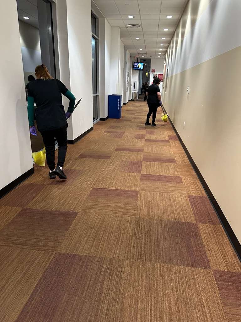 Caring Commercial Cleaning crew cleaning an office hallway in Houston