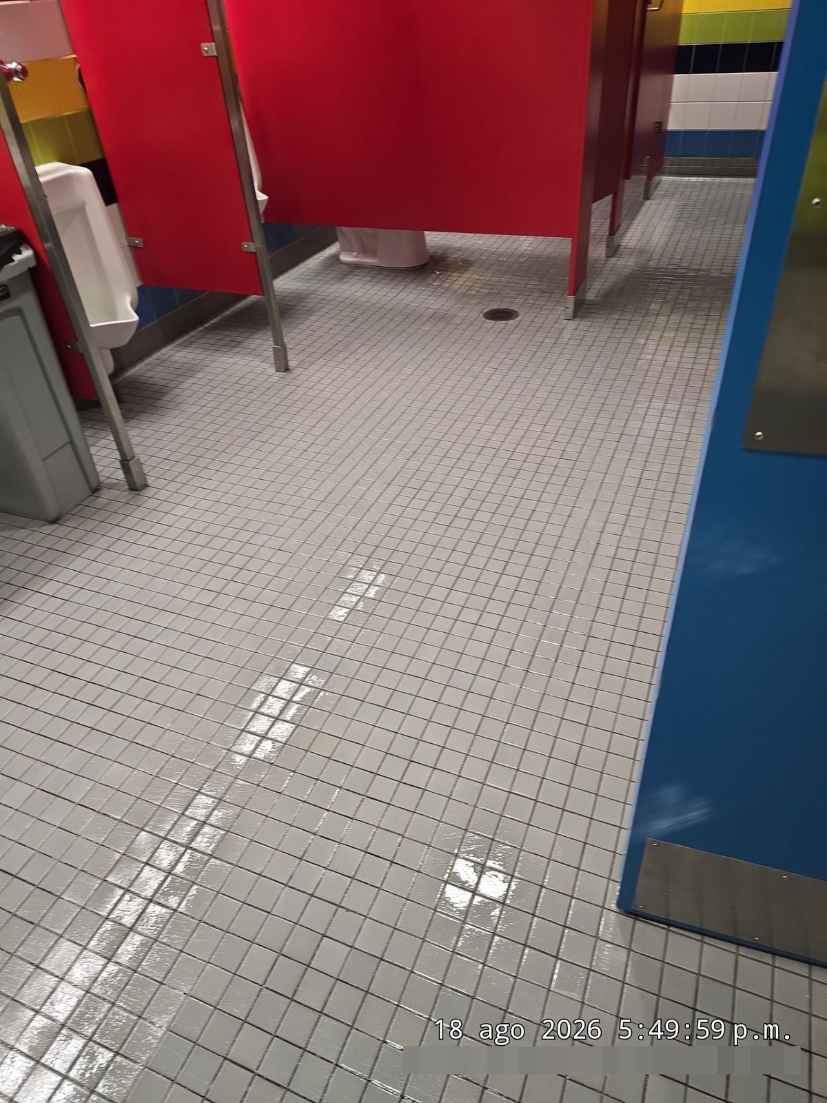 Freshly scrubbed and disinfected commercial restroom tile floor