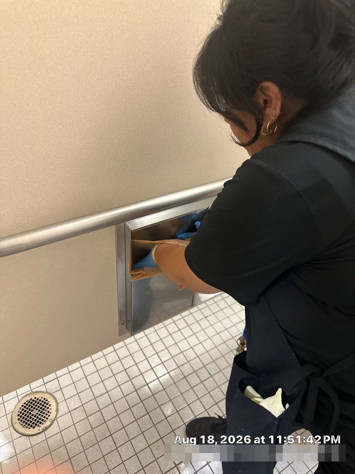 Technician restocking restroom dispenser