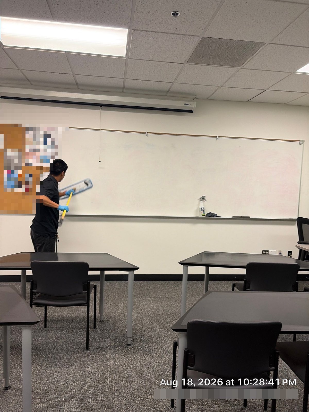 Cleaning technician washing classroom whiteboard