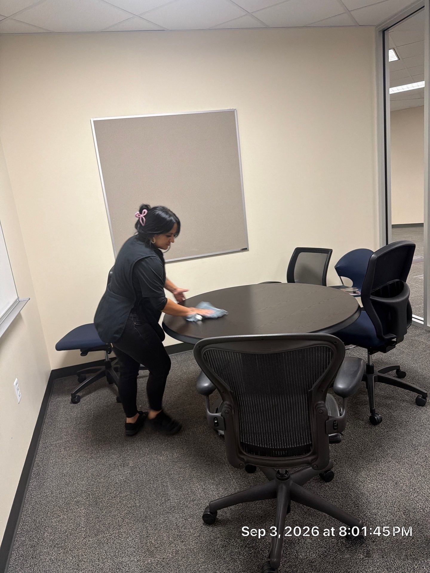 Caring Commercial Cleaning team member wiping a conference room table in a Houston office